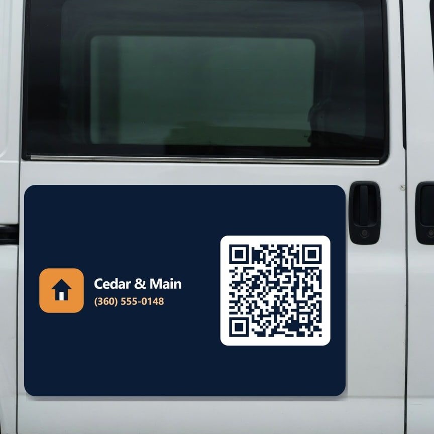 Large printed magnet with a logo, phone number, and QR code on a van door